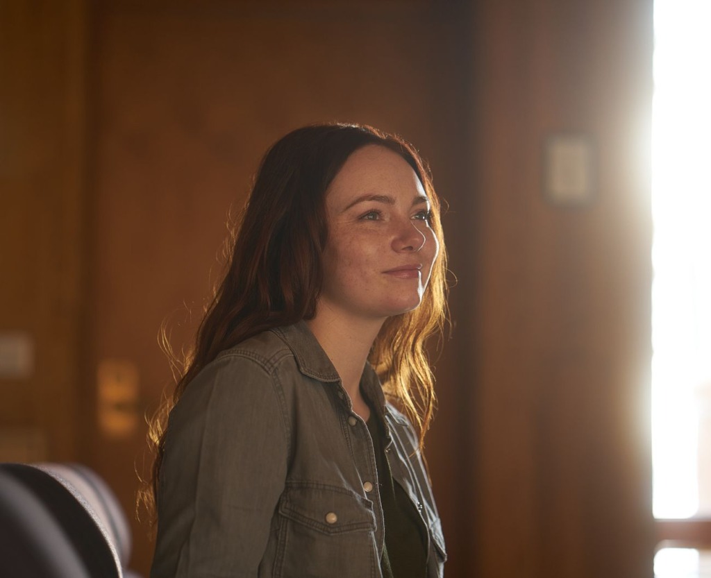 A smiling woman in warm light, thinking about her options